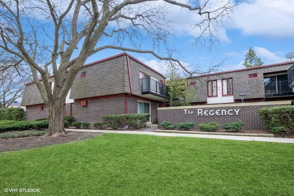 Front view of a two-story building with brick and wood siding.