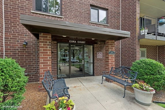Front view of a brick apartment building entrance named Cora Court.