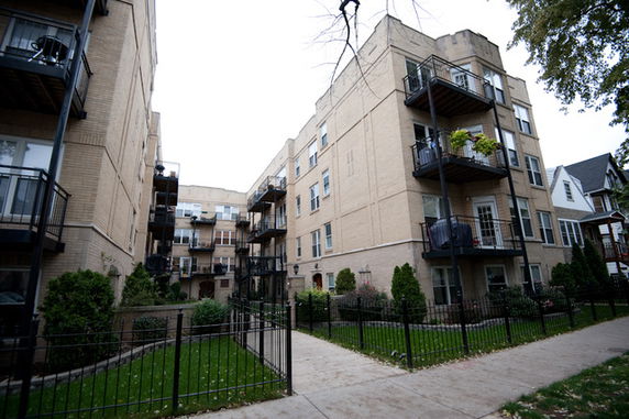 Front view of a multi-story apartment building with balconies.