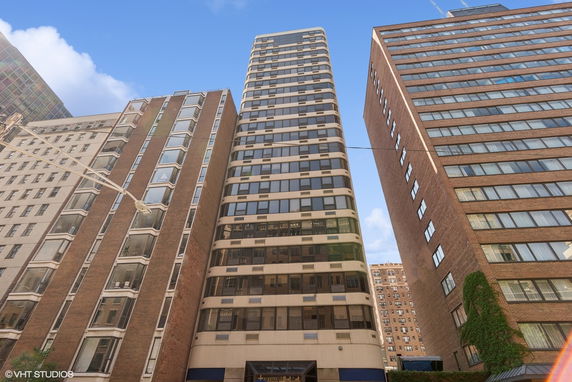 Front view of a tall multi-story building with modern design and large windows.