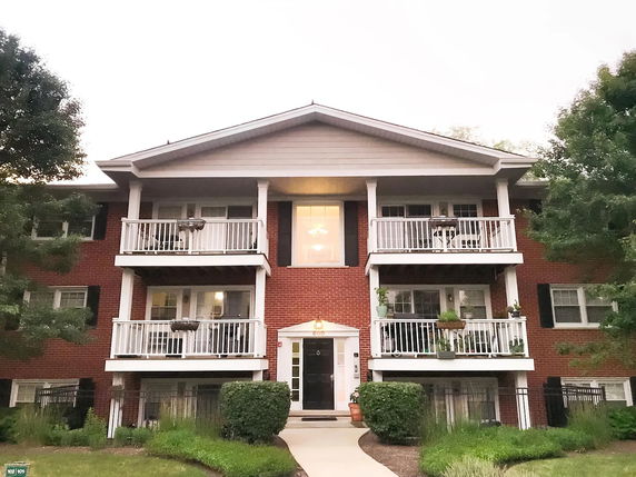 Front view of a multi-story brick building with balconies.