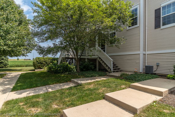 Exterior side view of a house with a porch and steps leading up to the entrance.