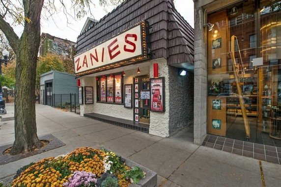 Front view of a building with a sign reading 'Zanies' and poster displays.