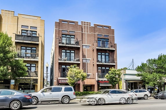 Front view of a multi-story brick building with balconies.