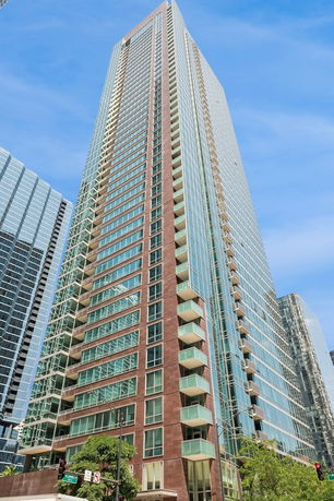 View of a tall skyscraper with glass windows and balconies