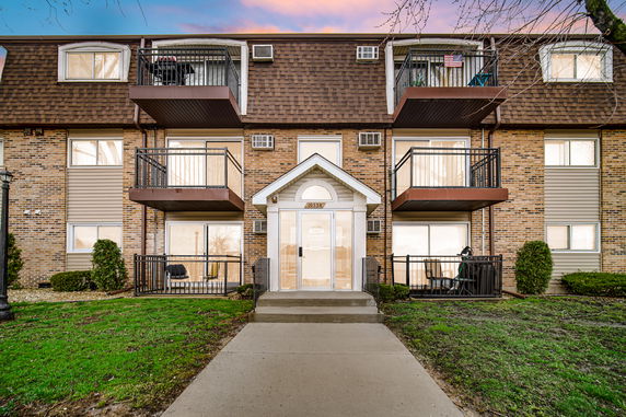 Front view of a multi-story residential building with balconies