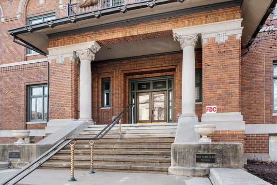 Front view of a brick building with classical columns and steps leading to the entrance.