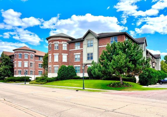 Front view of a multi-story brick building with a distinct corner tower.