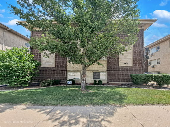 Front view of a multi-story brick apartment building.