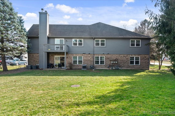 Rear view of a two-story house with a brick and siding exterior.