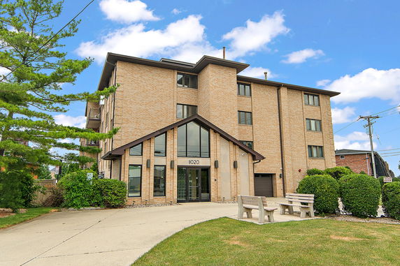 Front view of a multi-story building with a prominent glass entrance.