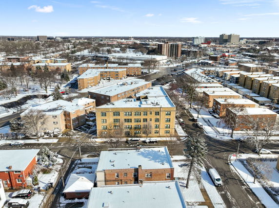 Aerial view of a residential area with multiple apartment buildings in a snowy landscape.
