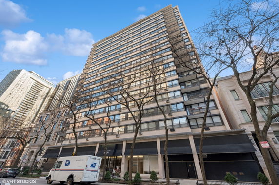 Front view of a tall residential building with large windows and balconies.