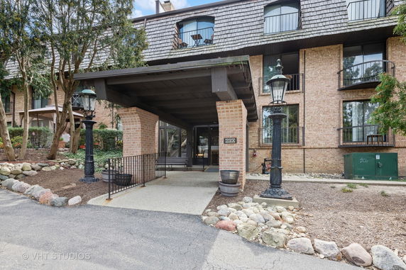 Front view of a multi-story brick building with covered entrance and balconies.