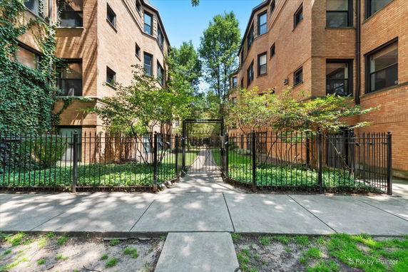 Front view of an apartment complex with a gated entrance and brick exterior.