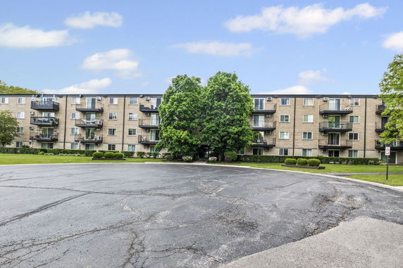 Front view of a multi-story apartment building with balconies.