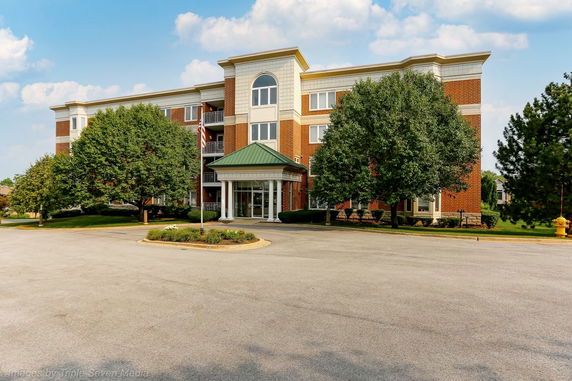 Front view of a multi-story building with brick facade and central entrance.
