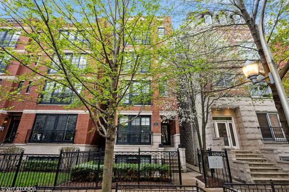 Front view of a multi-story brick apartment building with large windows.