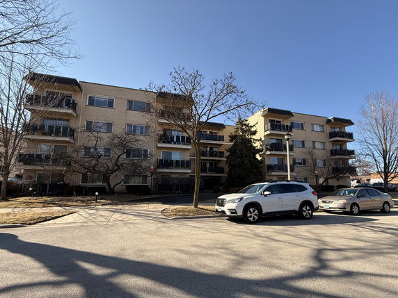 Front view of a four-story apartment building with balconies.
