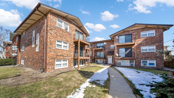 Front view of a multi-story brick apartment building.