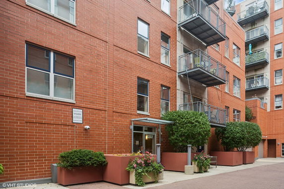 Front view of a brick apartment building with multiple balconies.