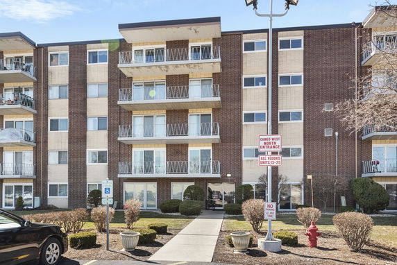 Front view of a multi-story apartment building with balconies.