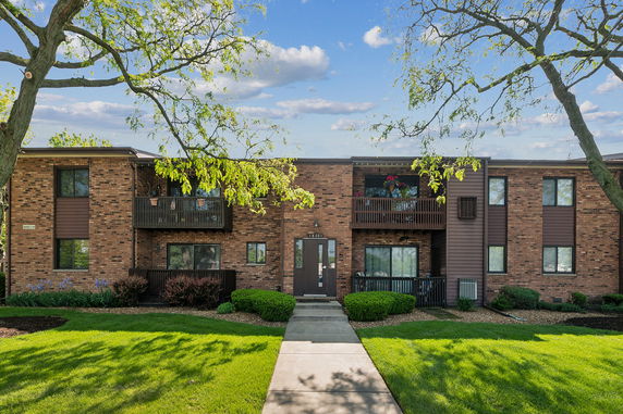 Front view of a two-story brick apartment building with balconies.