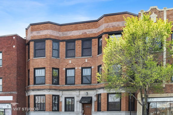 Front view of a three-story brick apartment building.