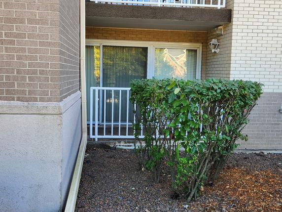 Front view of a building with sliding glass door and balcony.
