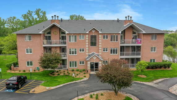 Front view of a multi-story brick apartment building with balconies.