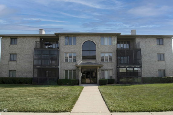 Front view of a multi-story residential building with balconies.