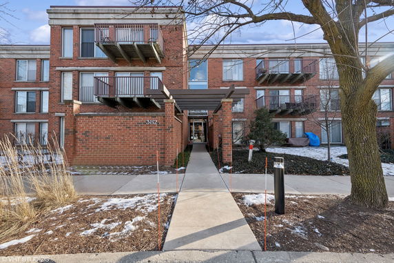 Front view of a multi-story brick building with balconies.