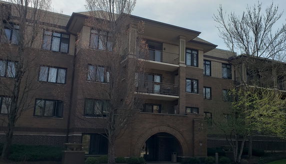 Front view of a multi-story brick building with balconies.