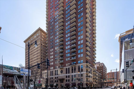 Front view of a tall residential building with multiple balconies.