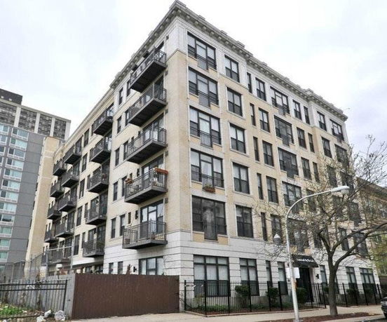 Front view of a multi-story apartment building with balconies.