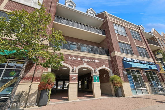 Front view of a multi-story building with retail shops on the ground floor.