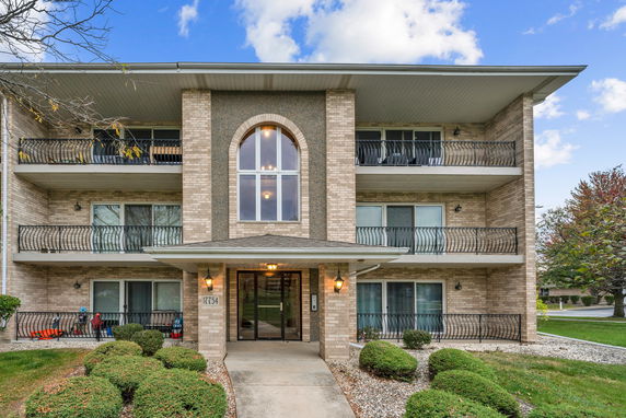 Front view of a three-story apartment building with balconies.