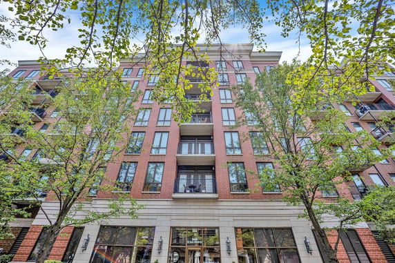 Front view of a multi-story brick building with balconies.