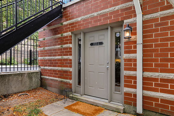 Entrance of a brick building with a gray door and outdoor light.