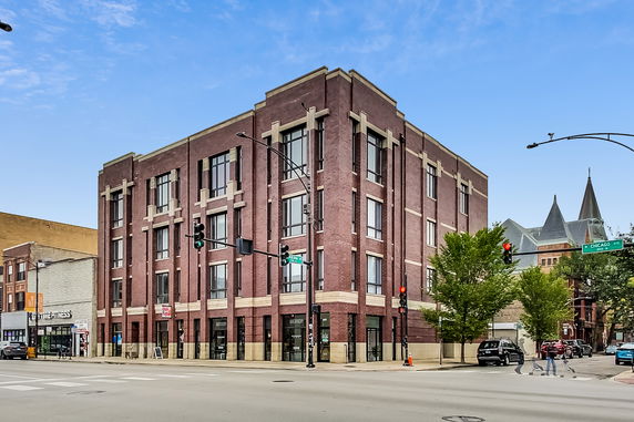 Front view of a multi-story brick building at an intersection.