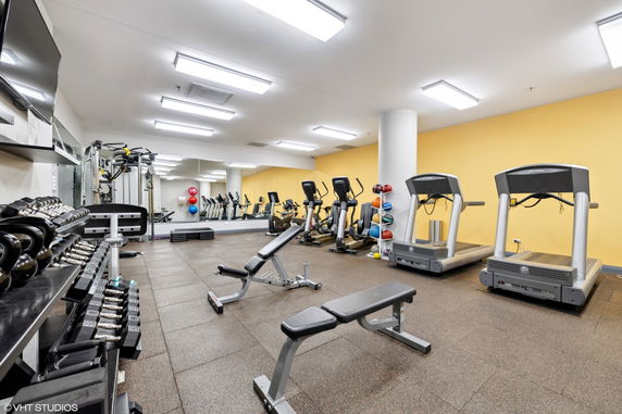 Indoor gym area with exercise equipment and yellow walls.