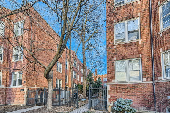 Front view of a brick apartment building with multiple windows.