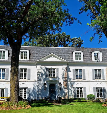 Front view of a two-story house with symmetrical windows and a central entrance.