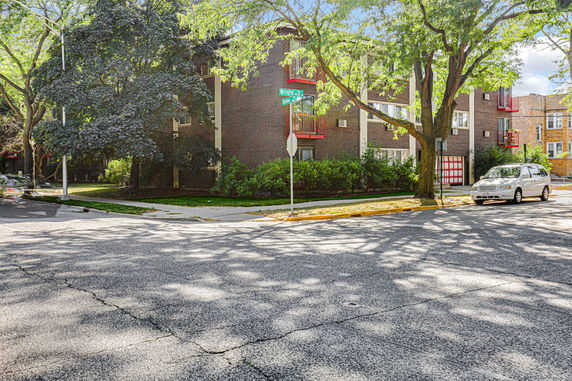 Front view of a multi-story brick building on a corner lot.