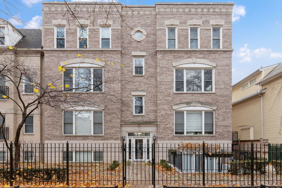 Front view of a three-story brick building with multiple windows.