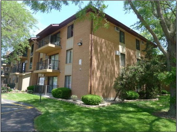 Side view of a multi-story brick apartment building.