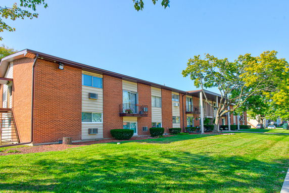 Front view of a two-story apartment building with brick and siding exterior.