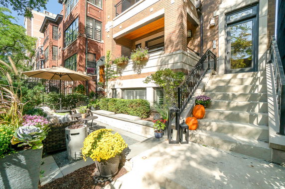 Front view of a multi-story brick apartment building with outdoor patio area.