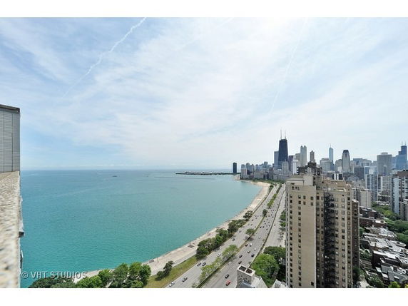Wide angle panoramic view showing a cityscape along a waterfront.