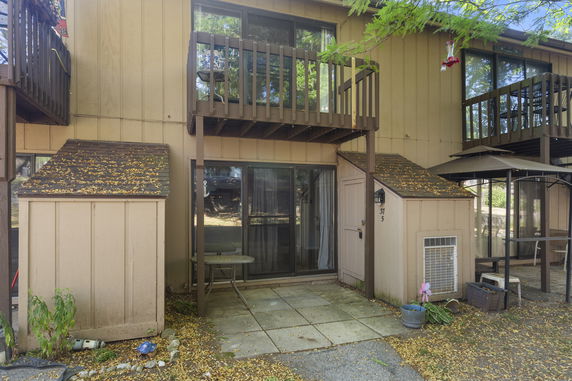 Front view of a two-story building with balconies and sliding glass doors.